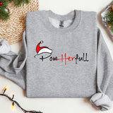a sweater with a santa hat on it next to a christmas tree