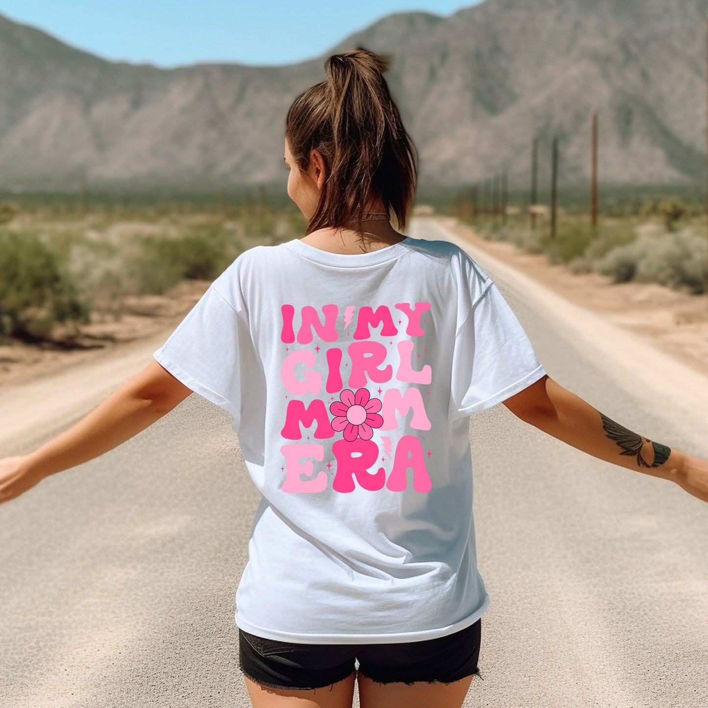 a woman walking down a road with her arms outstretched