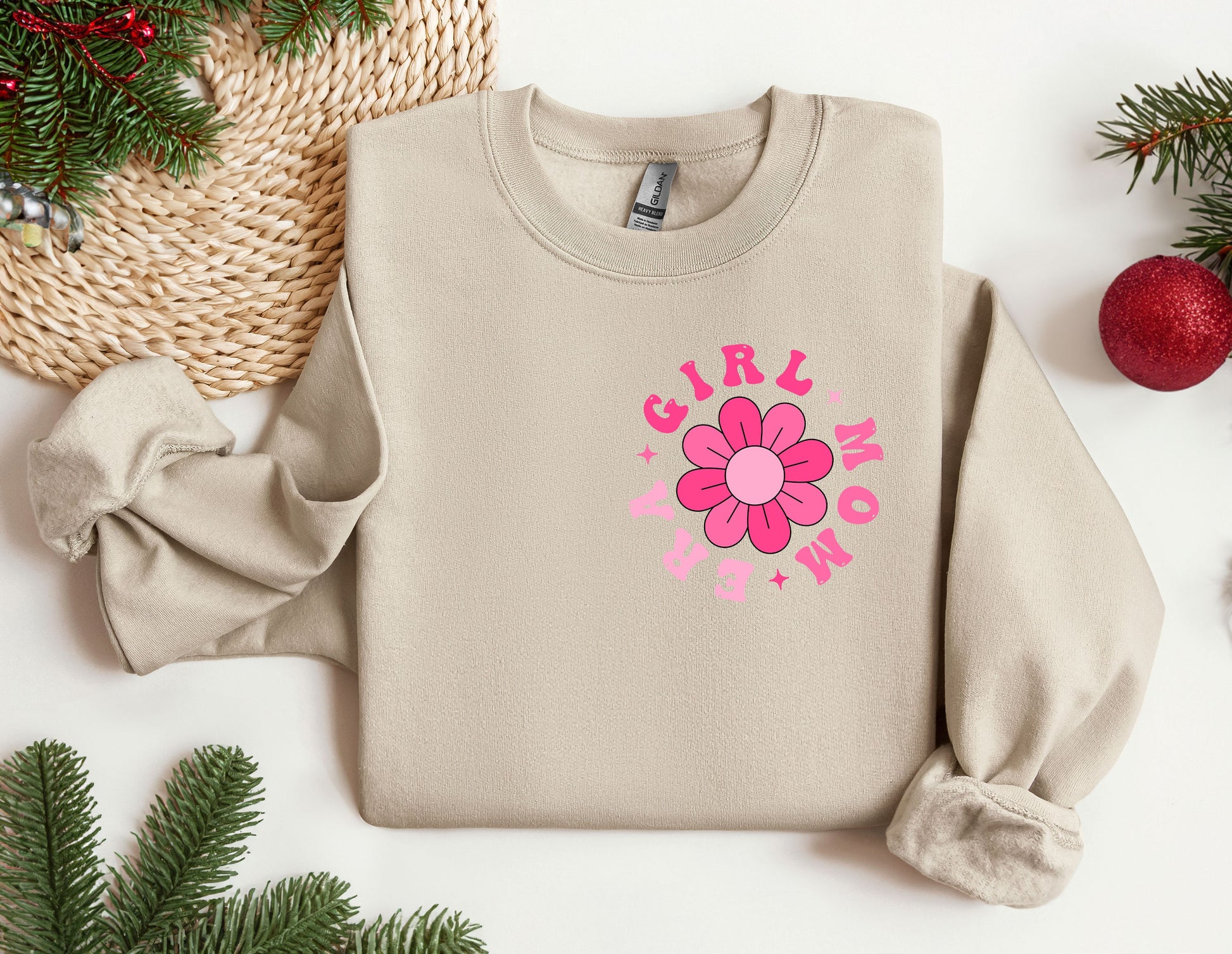 a sweater with a flower on it next to christmas decorations