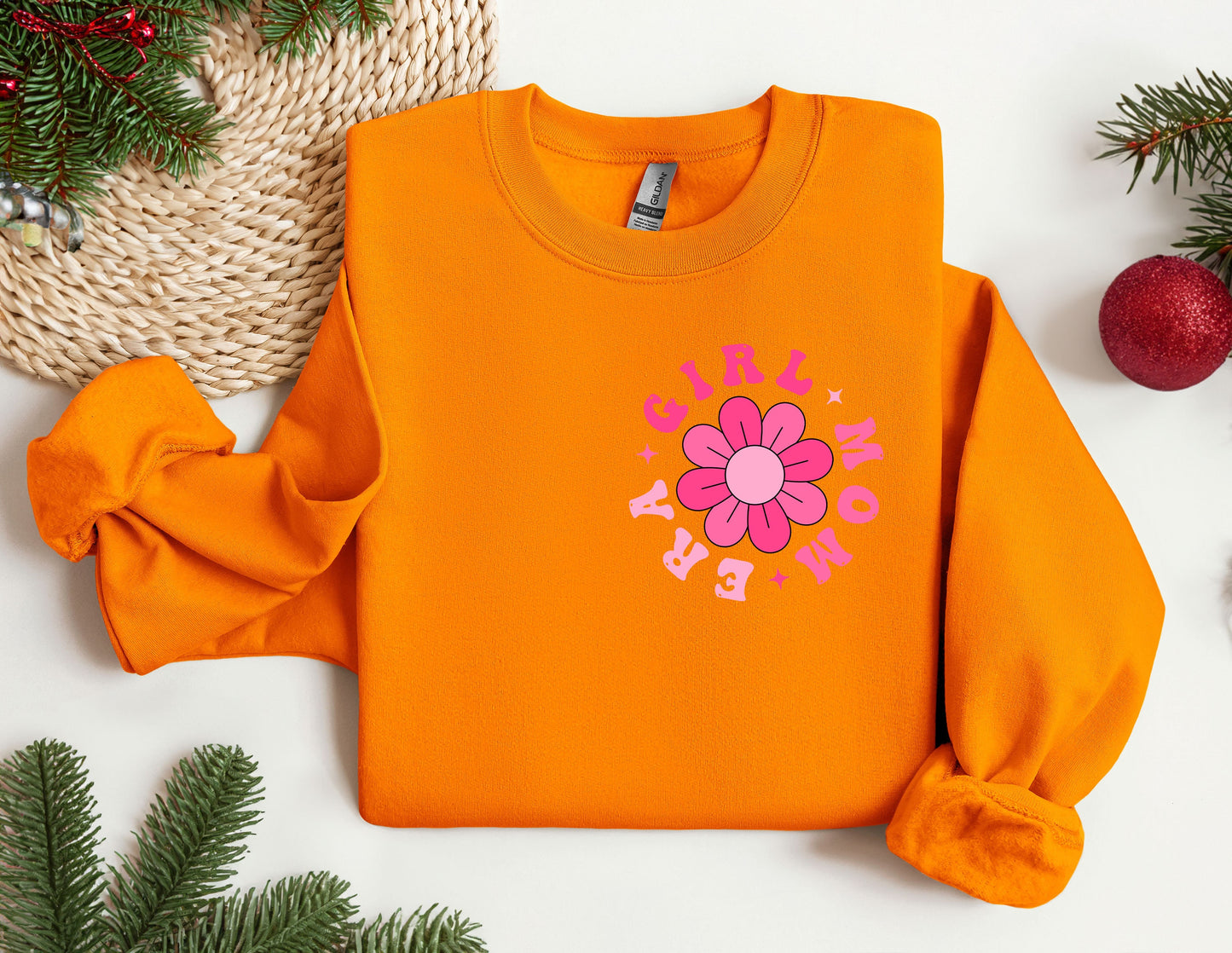 an orange sweatshirt with a flower on it