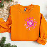 an orange sweatshirt with a flower on it