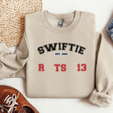 a sweater with the words swiffie on it next to a pair of shoes