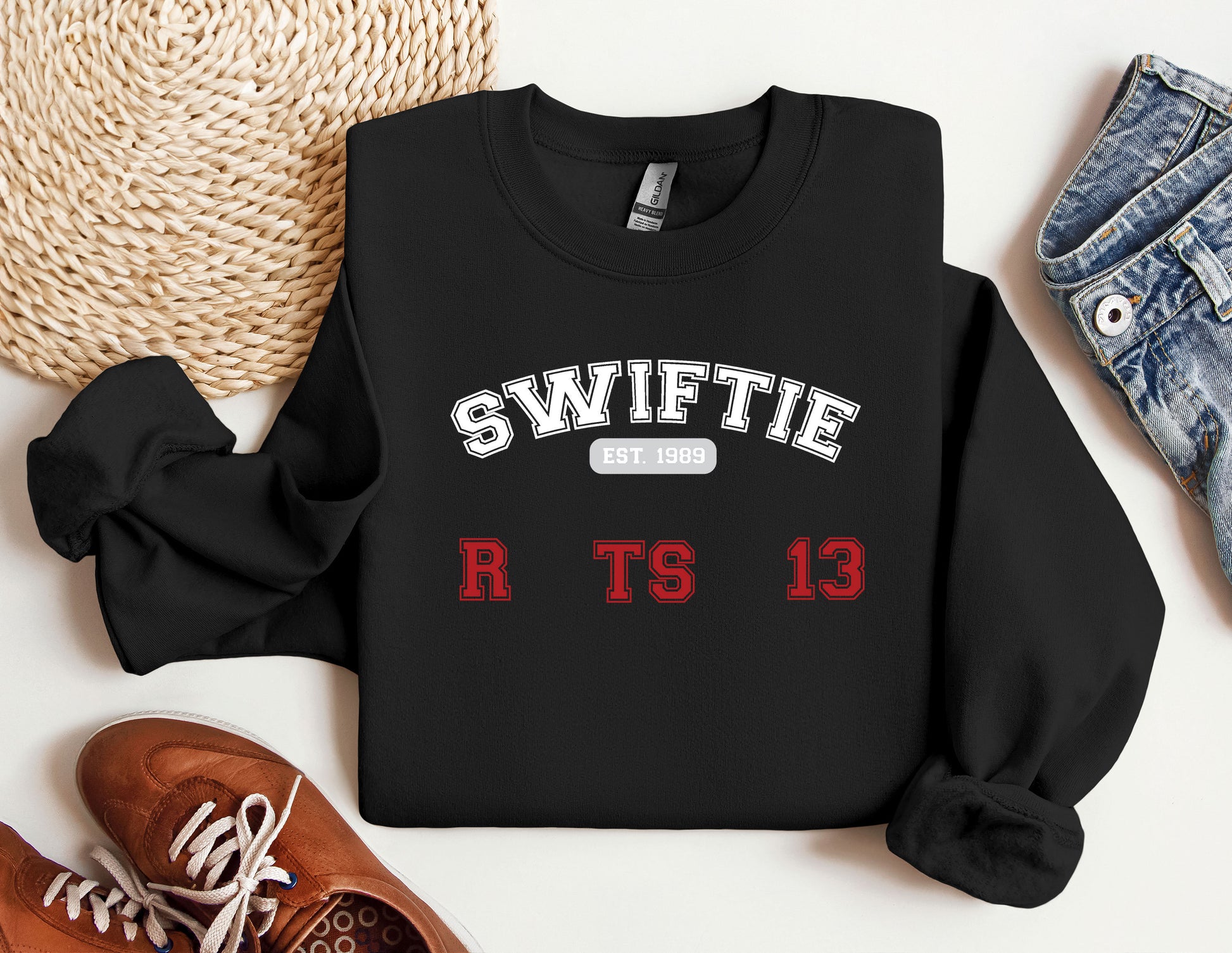 a black sweater with swiffie on it next to a pair of sneakers