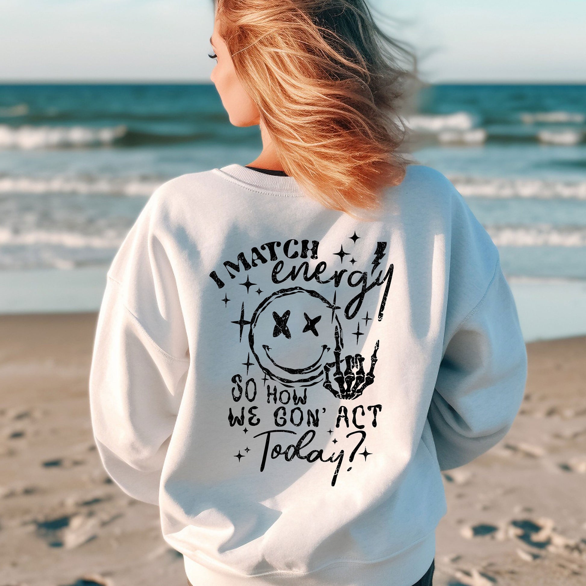 a woman standing on a beach with her back to the camera