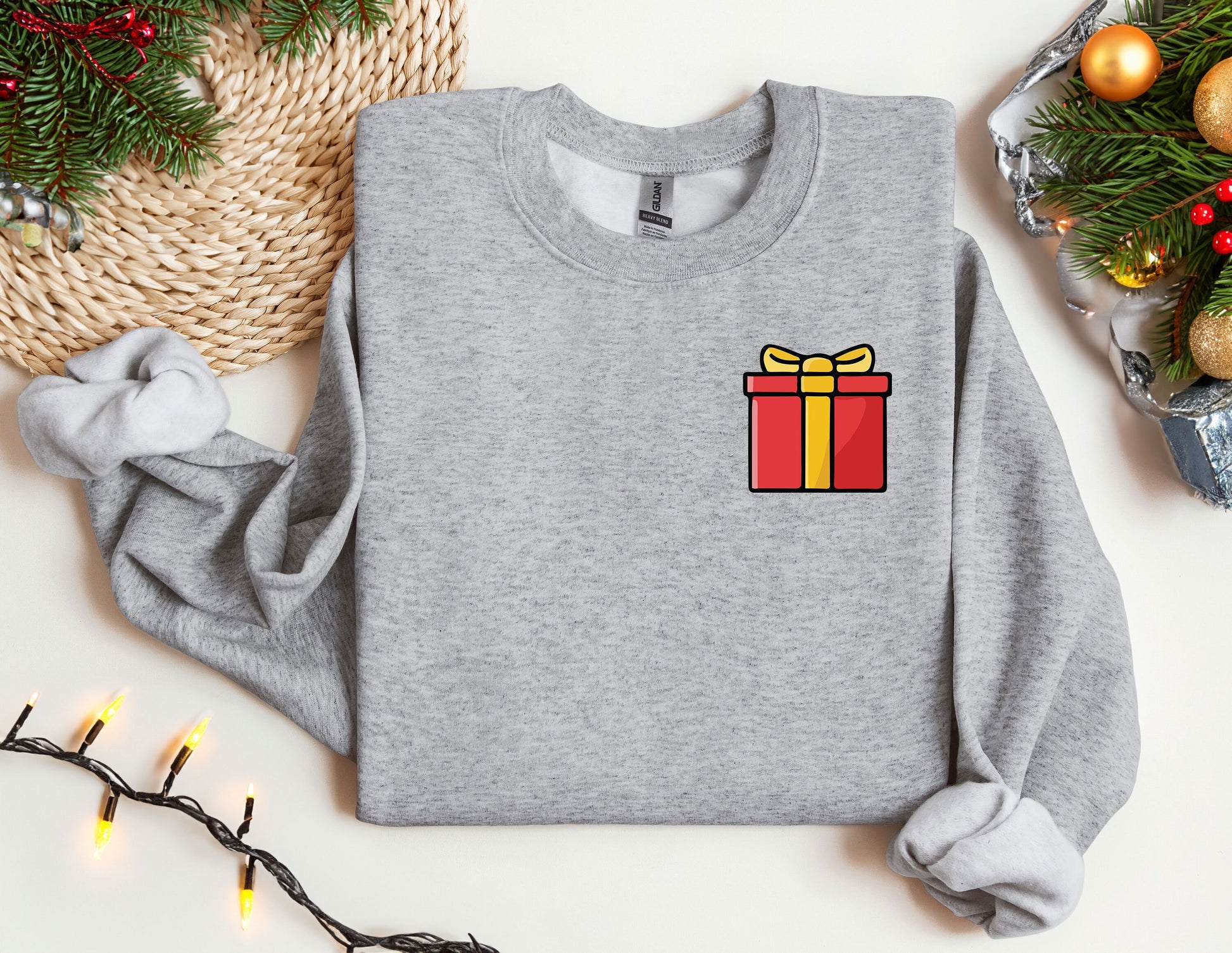 a sweater with a gift on it next to a christmas tree