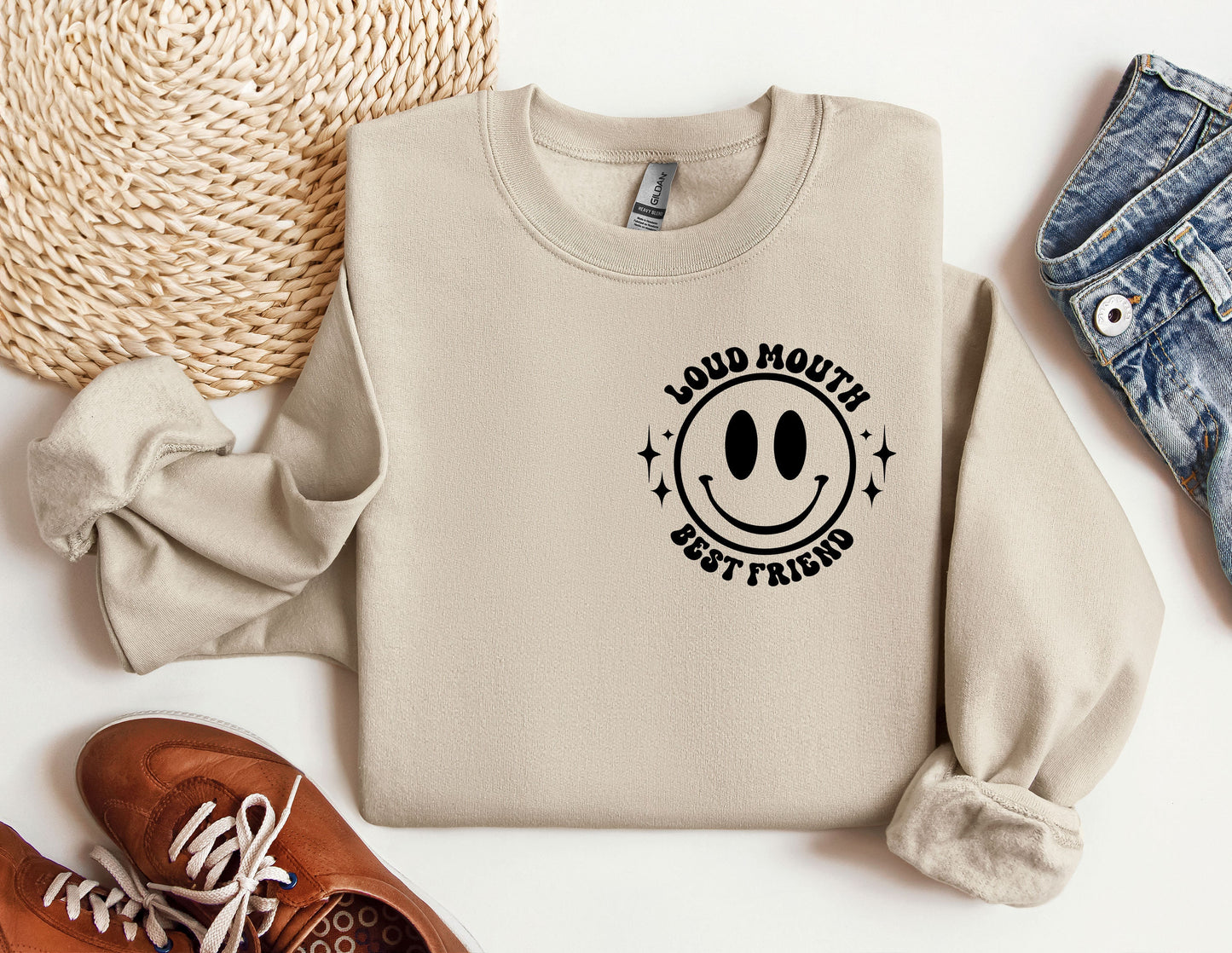 a sweater with a smiley face on it next to a pair of shoes