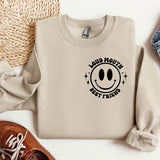 a sweater with a smiley face on it next to a pair of shoes