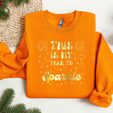 this is my year to sparkle sweatshirt on a table
