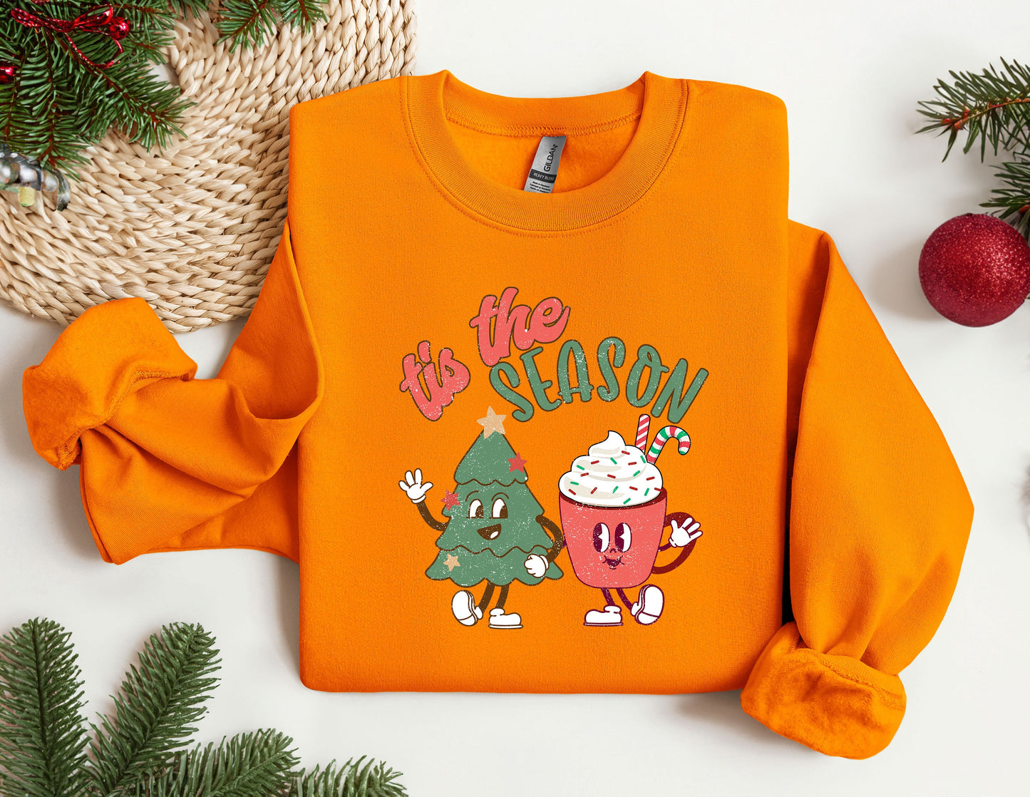 an orange sweatshirt with a christmas tree and cupcake on it