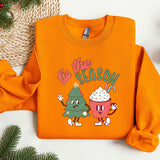 an orange sweatshirt with a christmas tree and cupcake on it