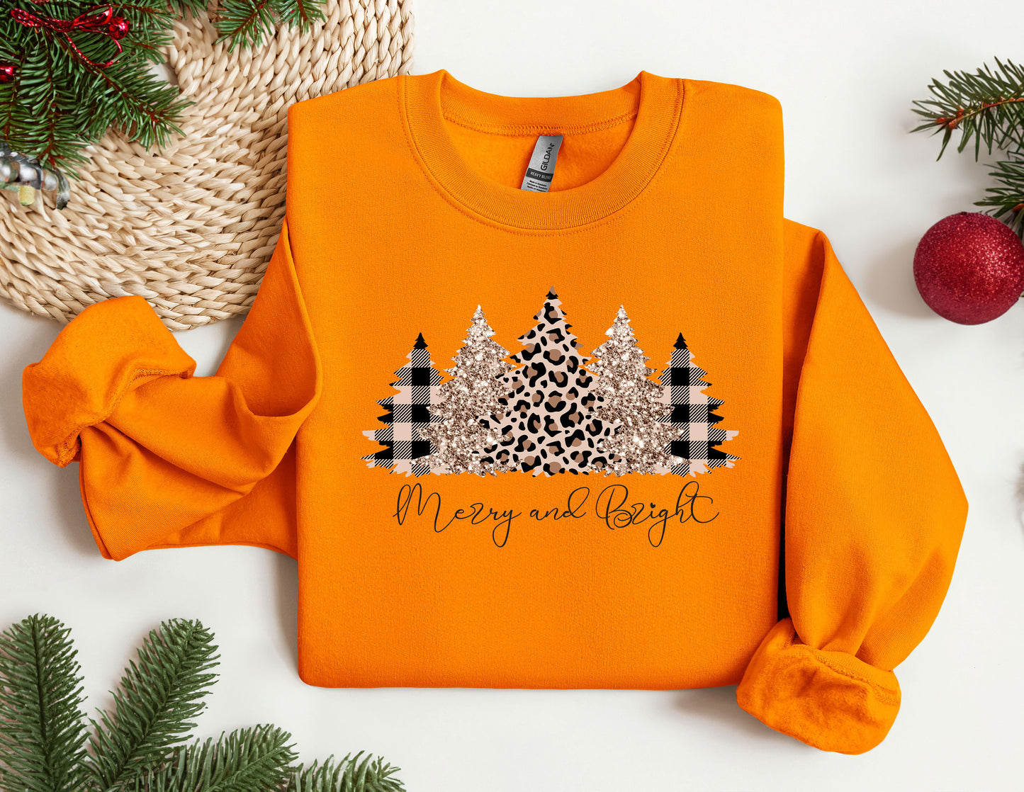 an orange sweater with a christmas tree on it