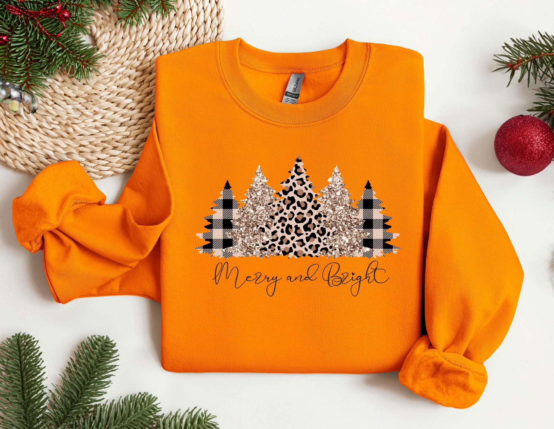 an orange sweater with a christmas tree on it