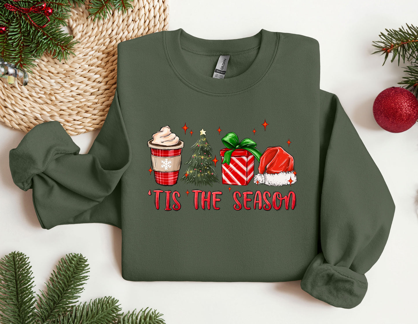 a green sweater with a cup of coffee and a christmas tree