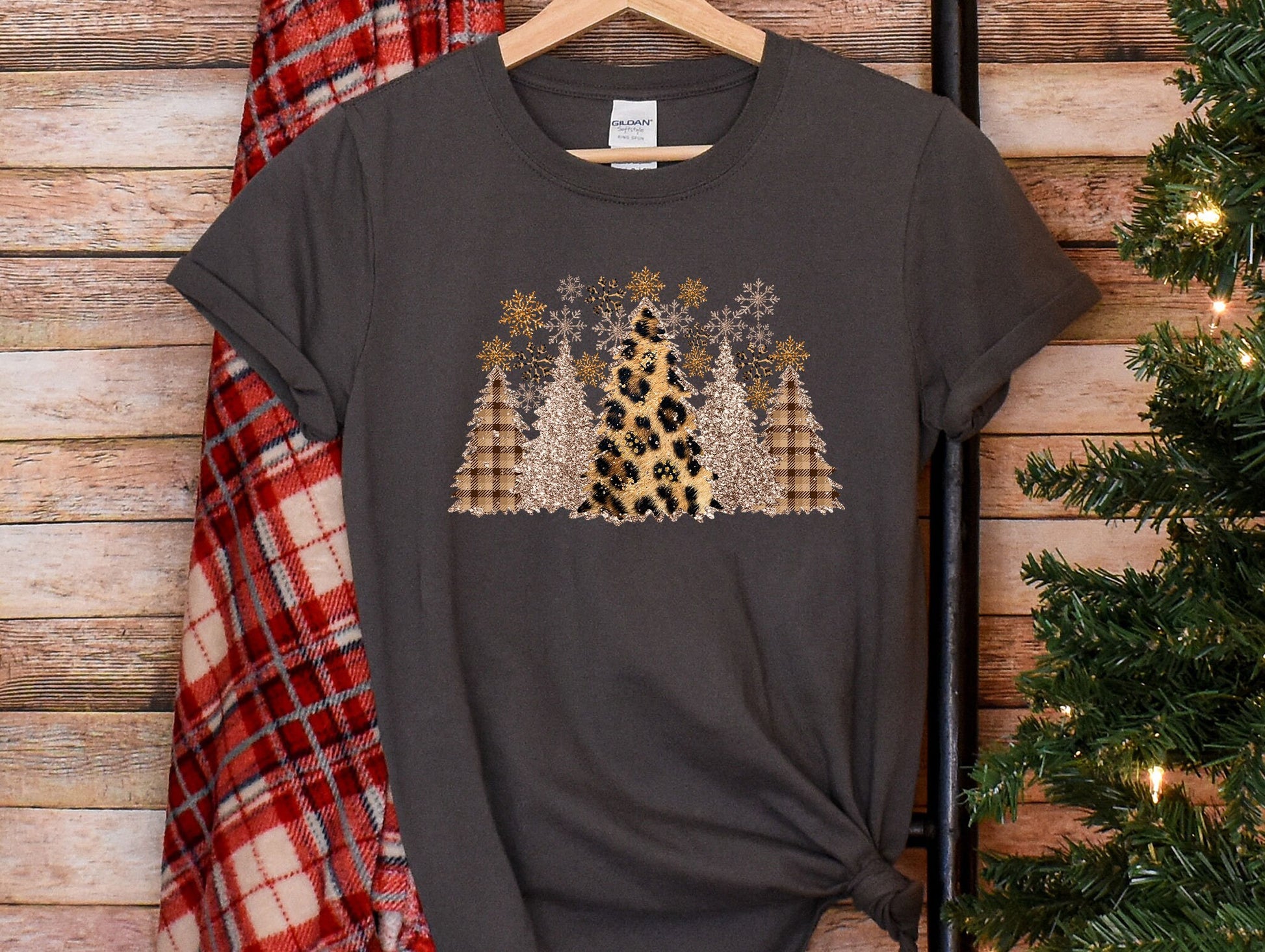 a t - shirt with a leopard print on it next to a christmas tree