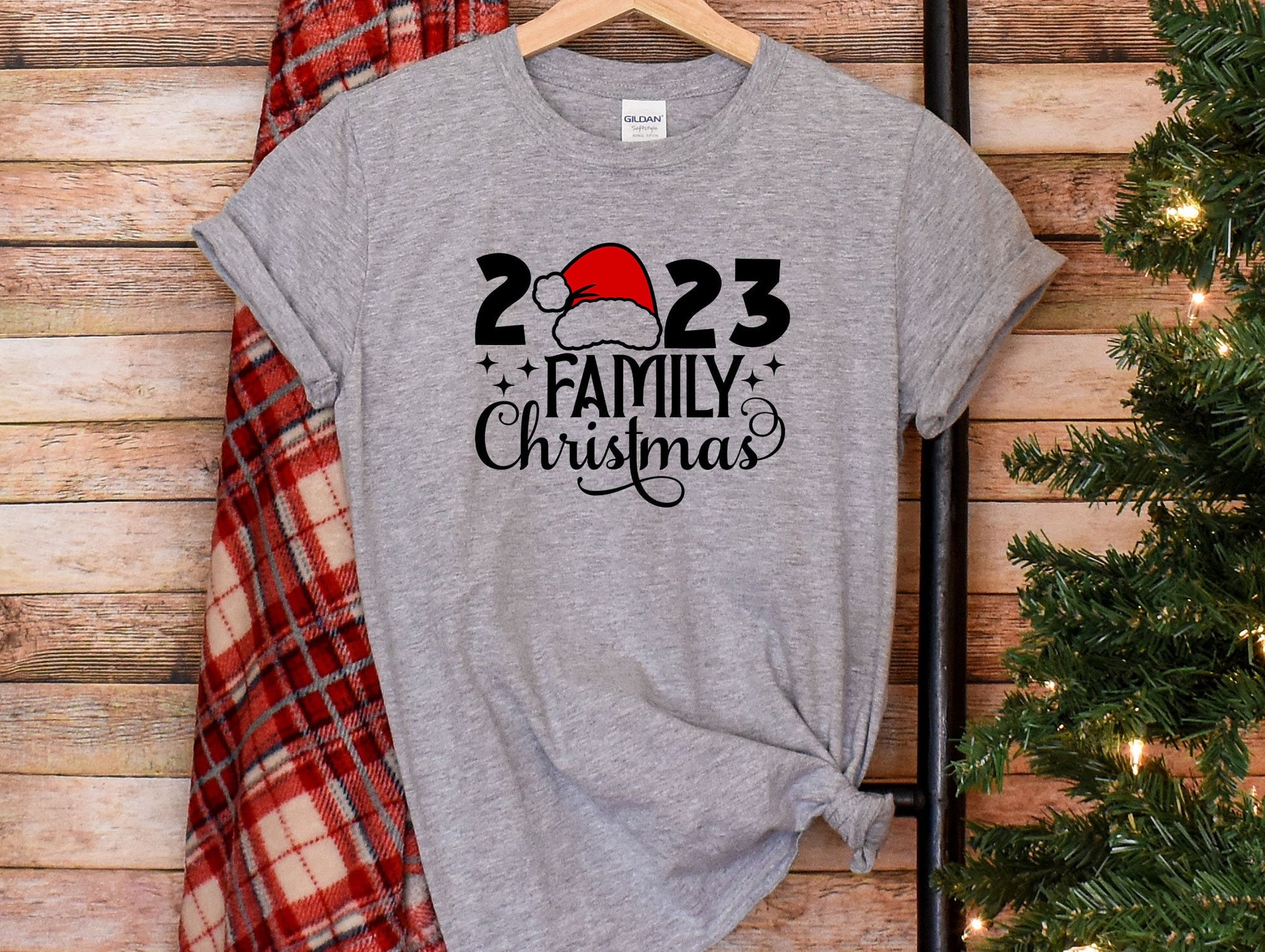 a t - shirt with a santa hat on it next to a christmas tree