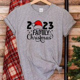 a t - shirt with a santa hat on it next to a christmas tree