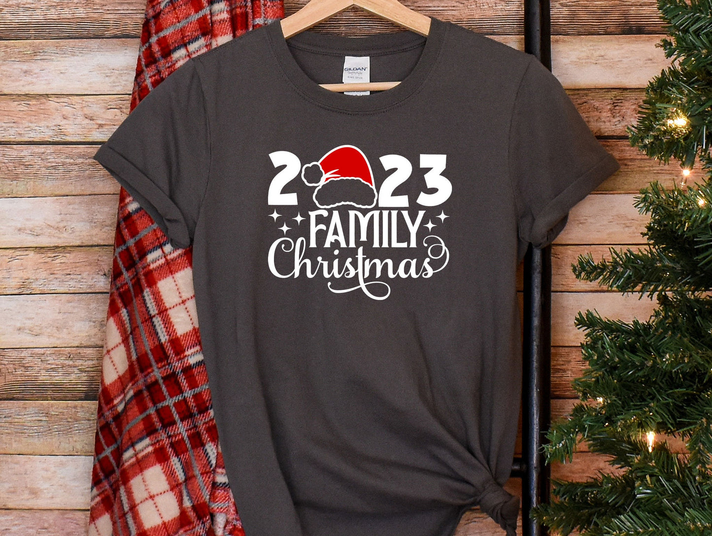 a t - shirt with a santa hat on it next to a christmas tree