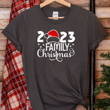 a t - shirt with a santa hat on it next to a christmas tree