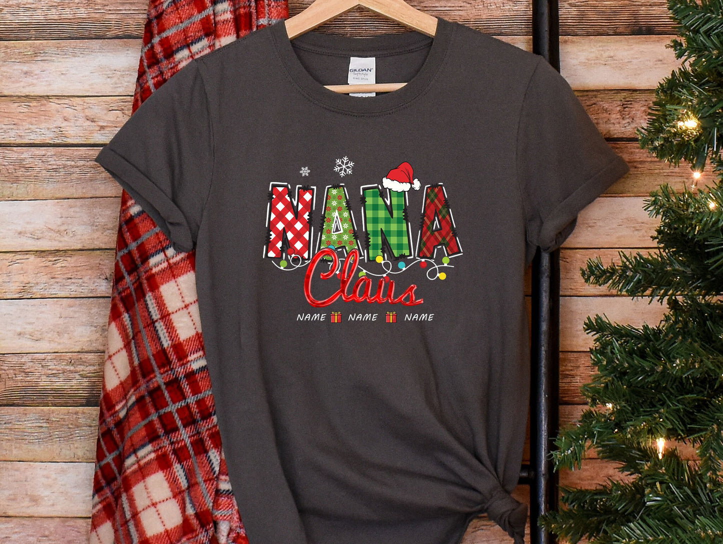 a t - shirt with the word santa claus on it next to a christmas tree