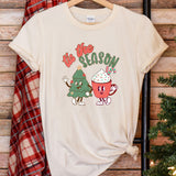 a t - shirt that says tis the season next to a christmas tree