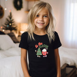 a little girl that is standing in front of a bed