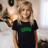 a little girl that is standing in front of a bed