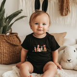 a baby sitting on a bed next to a stuffed animal