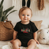 a baby sitting on a bed wearing a black shirt and bunny ears