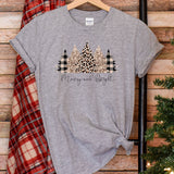 a t - shirt that says merry and bright on it next to a christmas tree