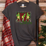 a t - shirt hanging on a wooden wall next to a christmas tree