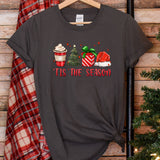 a t - shirt that says tis the season next to a christmas tree