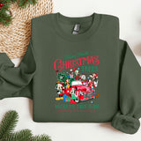 a green christmas sweater with a red truck and santa clause on it