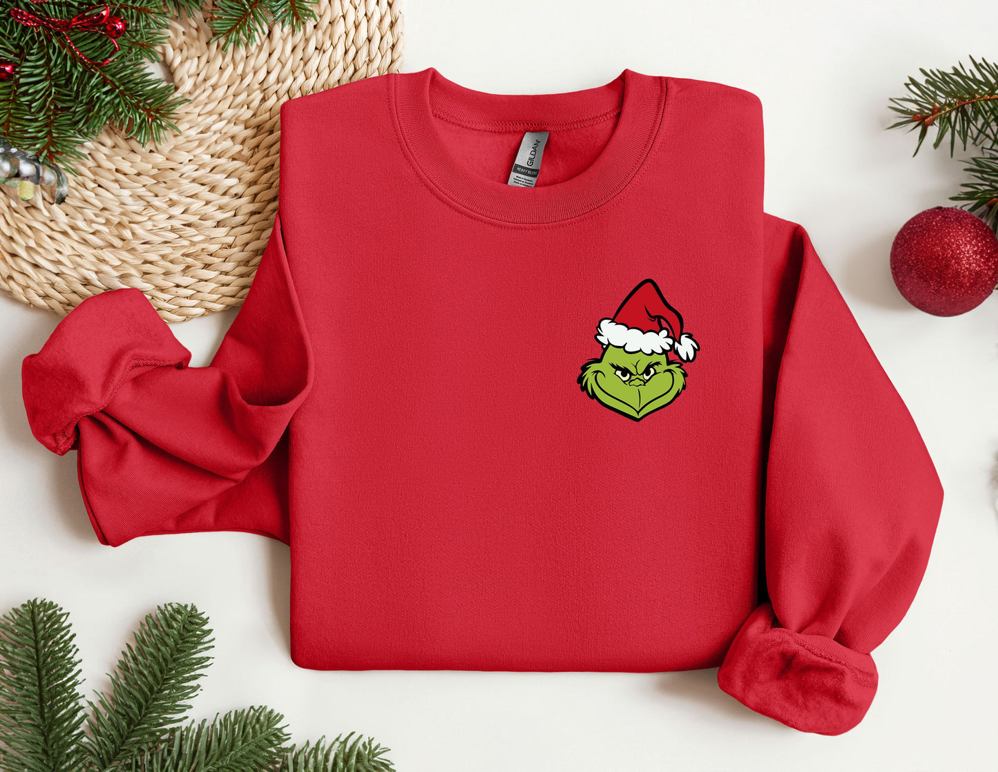 a red sweater with a green grin face on it