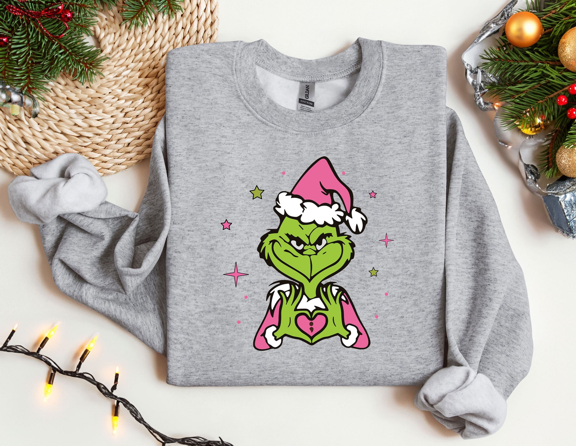 a grey sweatshirt with a picture of the grin face wearing a santa hat