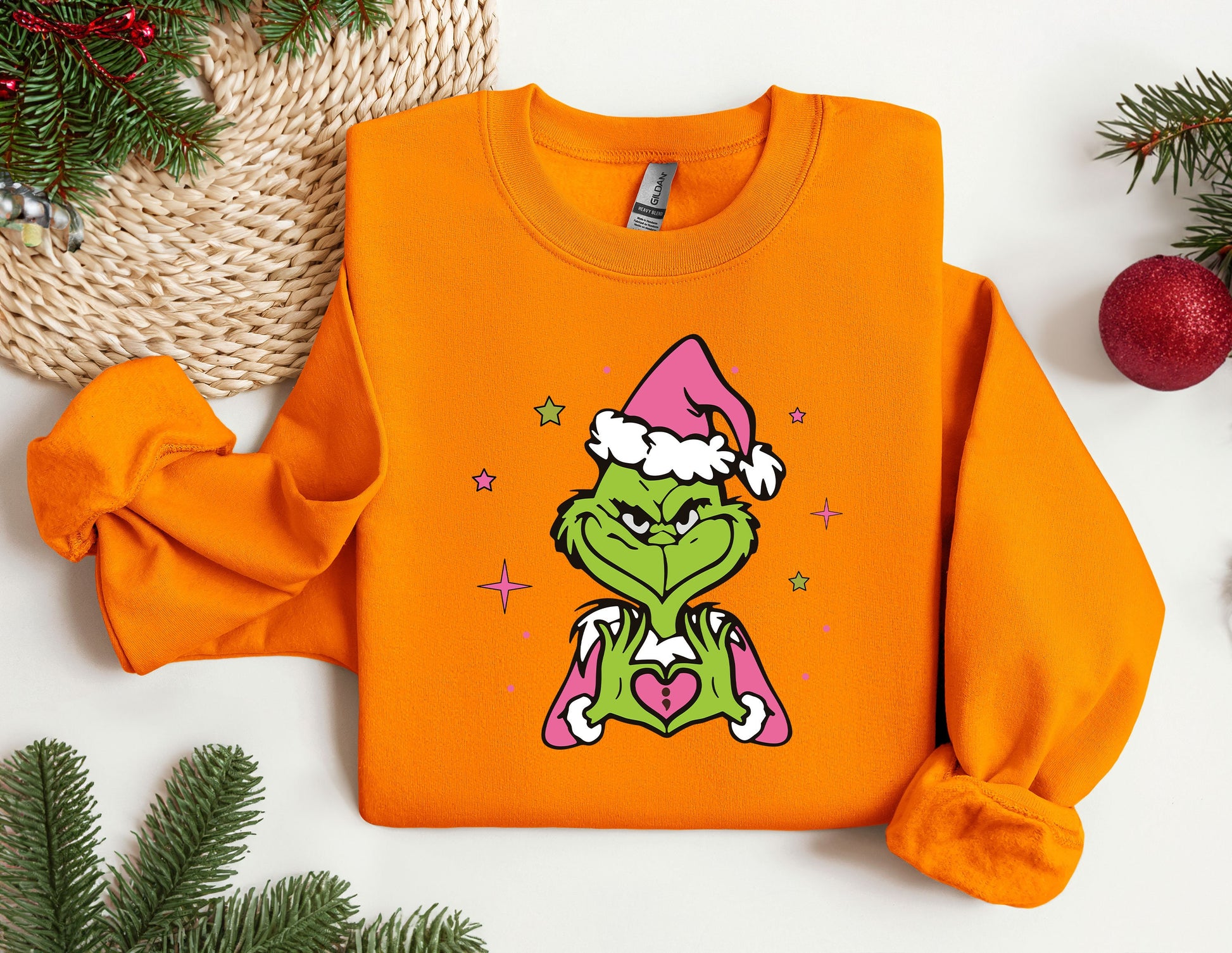 an orange shirt with a picture of a grin face wearing a santa hat