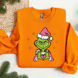 an orange shirt with a picture of a grin face wearing a santa hat