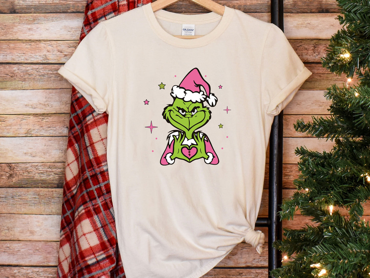 a t - shirt with the grin face on it next to a christmas tree