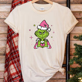 a t - shirt with the grin face on it next to a christmas tree