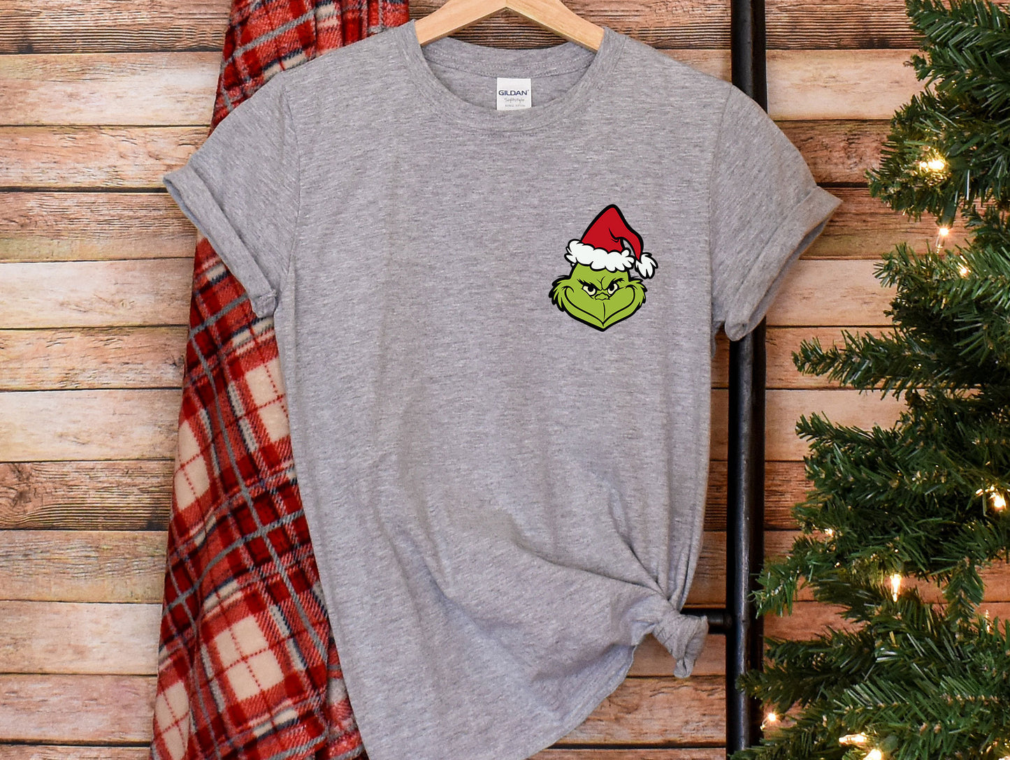 a t - shirt with the grin face on it next to a christmas tree