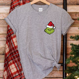 a t - shirt with the grin face on it next to a christmas tree