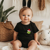 a baby sitting on a bed wearing a black shirt and bunny ears