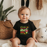 a baby sitting on a bed wearing a black shirt