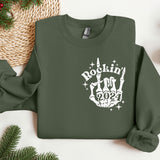 a green sweatshirt with a rockin'n'rollin'hand on it