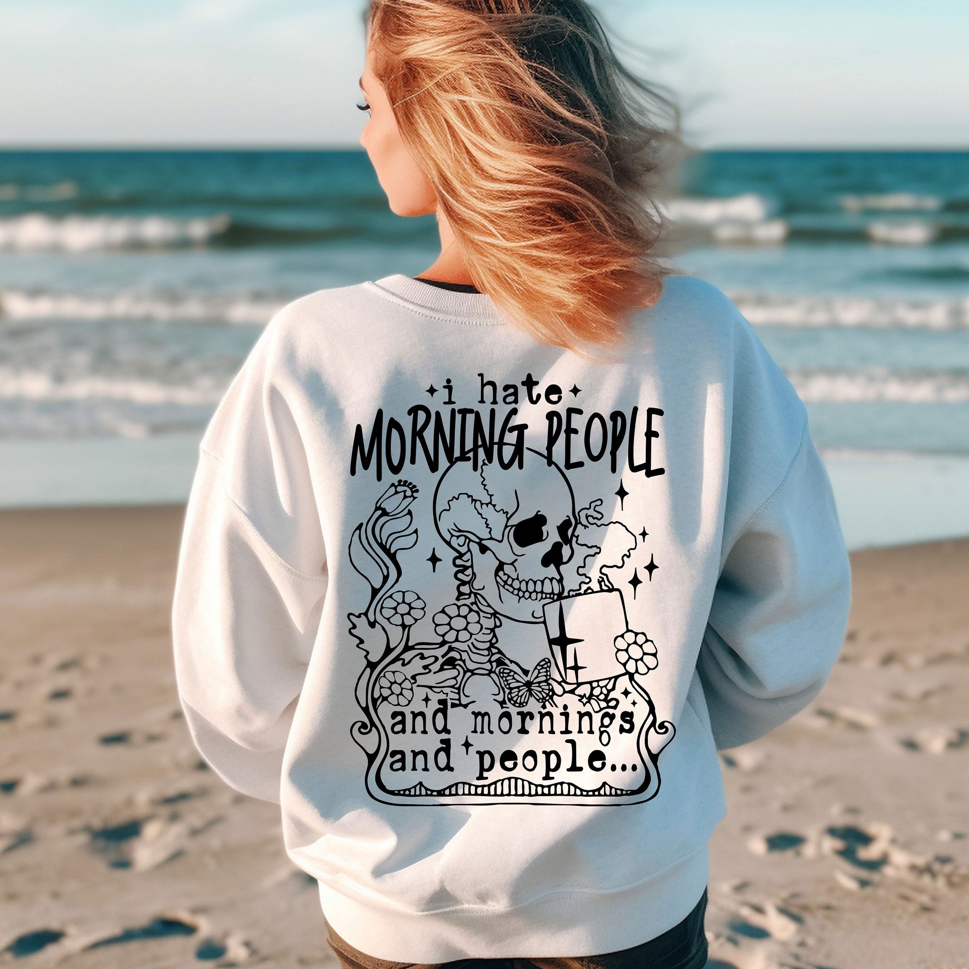 a woman standing on a beach with her back to the camera