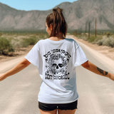 a woman walking down a road with her arms outstretched