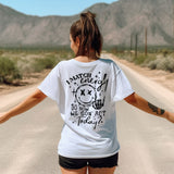 a woman walking down a road with her arms outstretched
