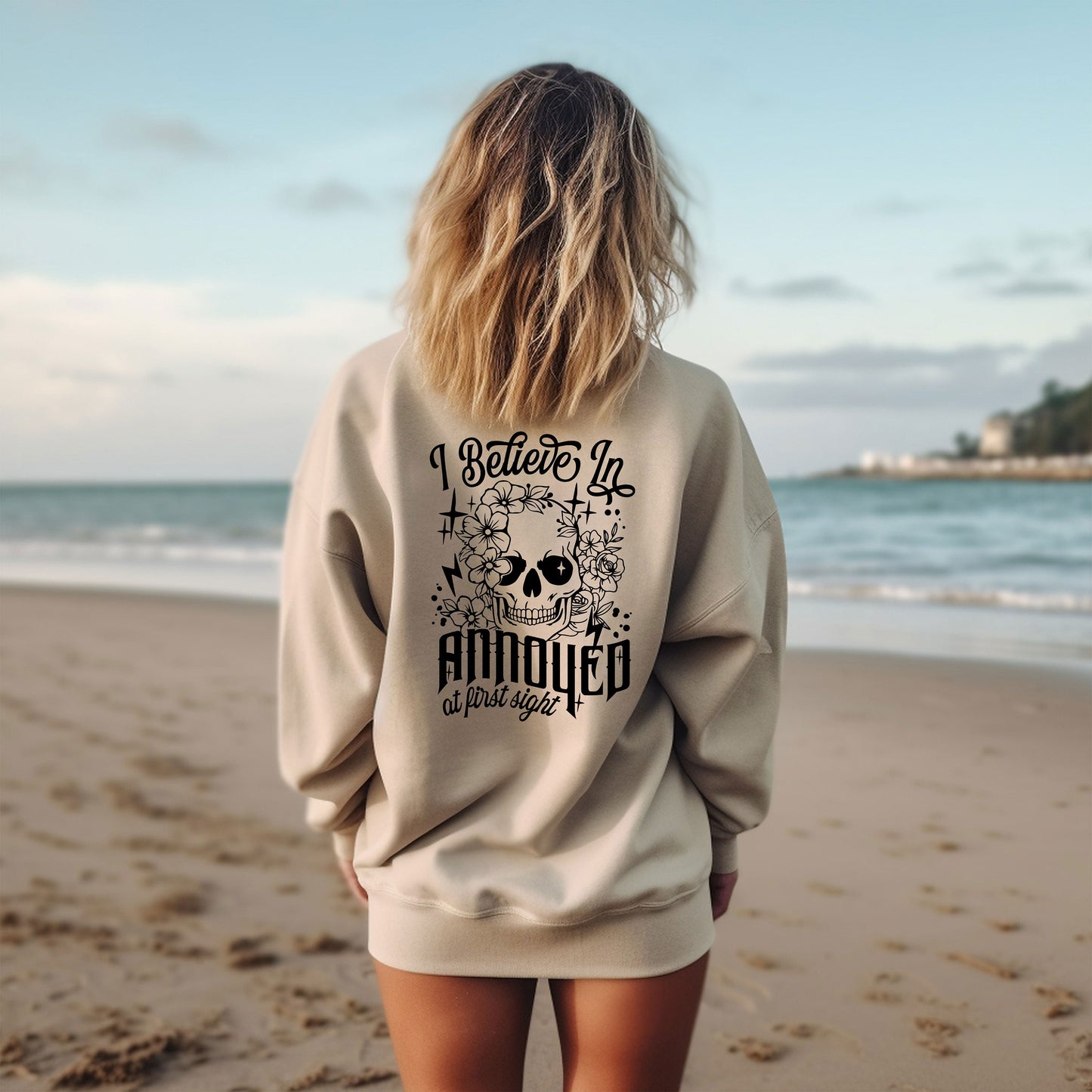 a woman standing on a beach with her back to the camera