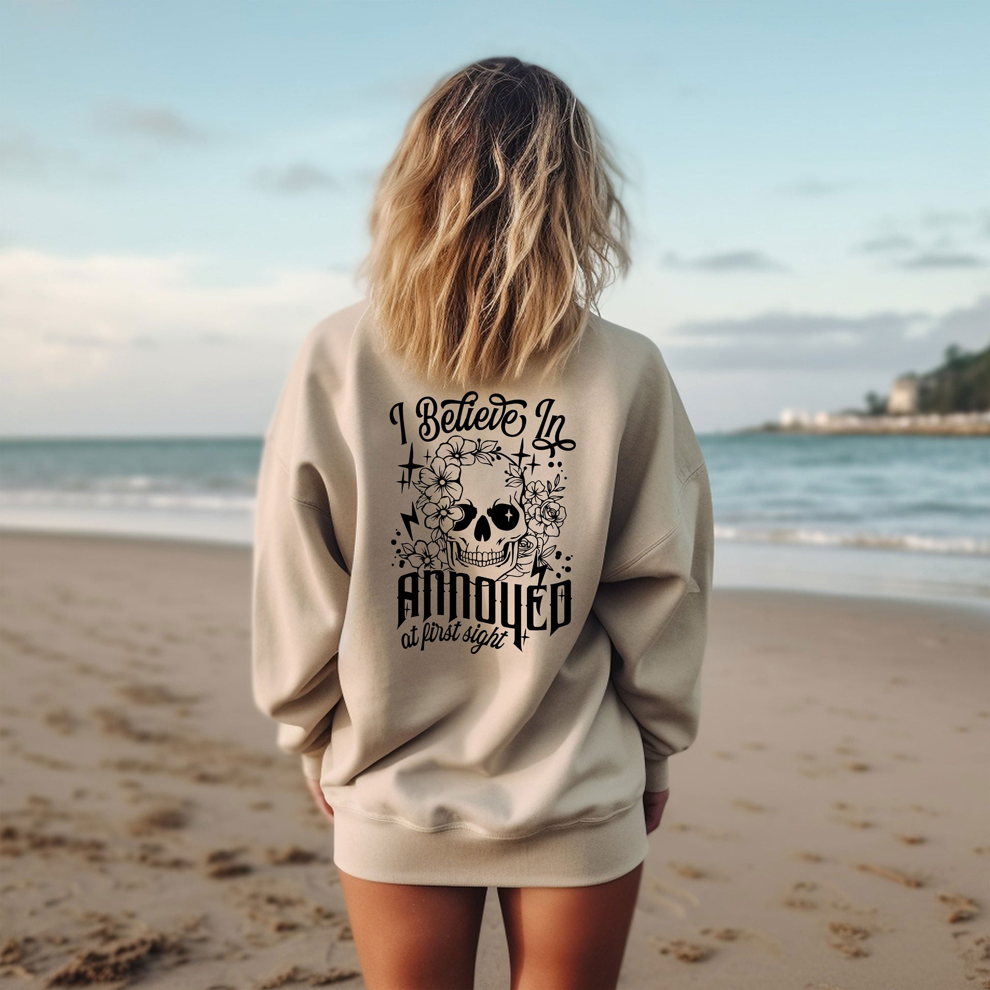 a woman standing on a beach with her back to the camera