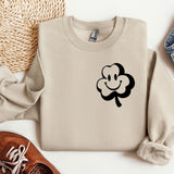 a sweater with a clover on it next to a pair of shoes