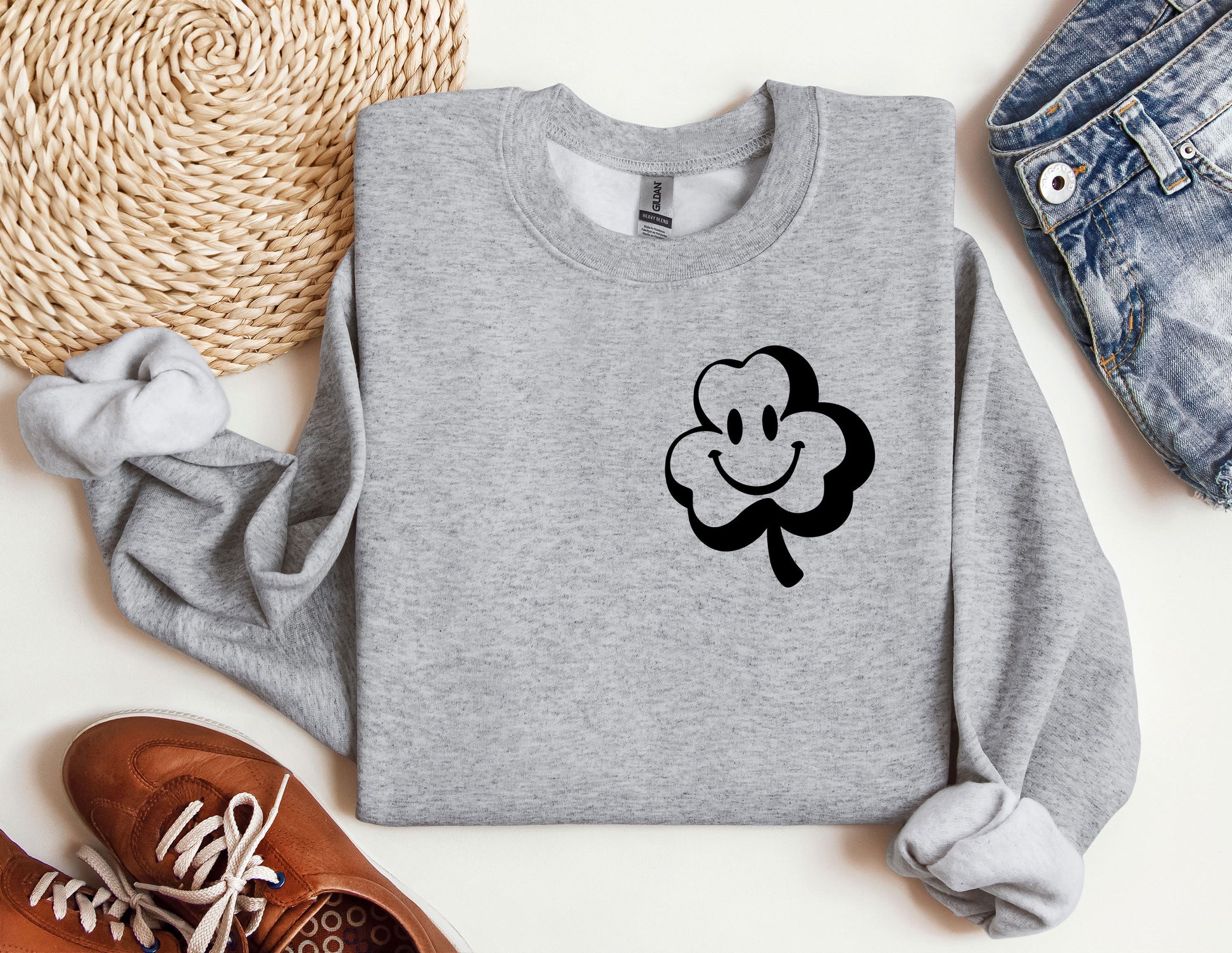 a sweater with a clover on it next to a pair of shoes